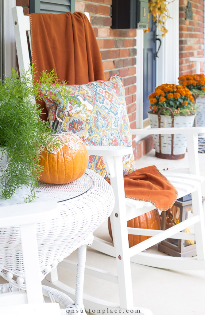 https://www.onsuttonplace.com/wp-content/uploads/2015/09/2022-fall-decor-on-front-porch-with-white-rockers-668x1024.jpg