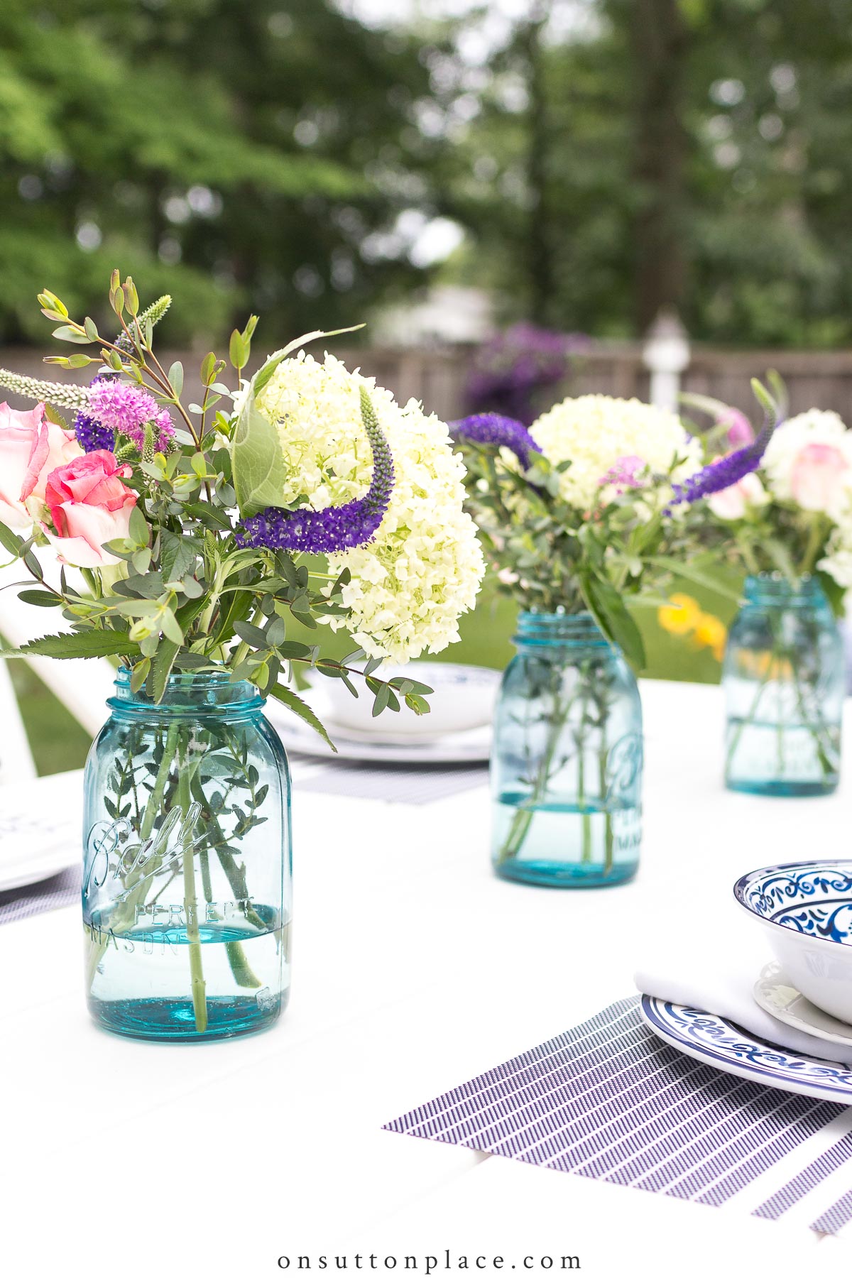 https://www.onsuttonplace.com/wp-content/uploads/2019/02/row-of-blue-mason-jars-on-outdoor-table-2022.jpg