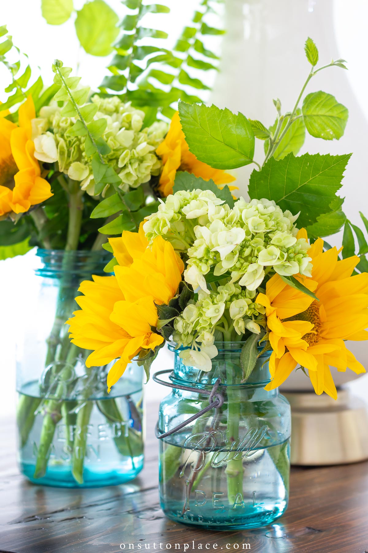 https://www.onsuttonplace.com/wp-content/uploads/2019/02/sunflowers-and-hydrangeas-in-blue-mason-jars.jpg