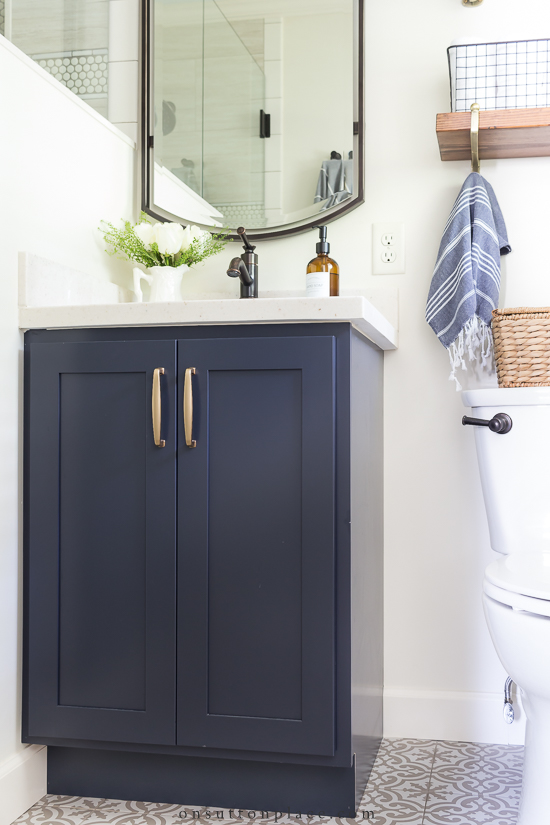 https://www.onsuttonplace.com/wp-content/uploads/2020/09/navy-blue-vanity-in-small-master-bathroom.jpg